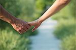 Couple hesitantly hold hands, close-up