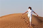 Girl ascending sand dune