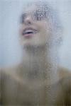 Woman behind wet glass, head back, close-up