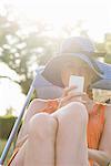 Young woman relaxing outdoors with smartphone