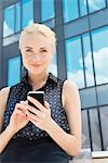 Young businesswoman using smartphone outdoors