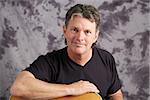 Handsome, middle-aged musician posing with his guitar.