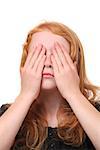 Young girl covering her eyes on white background