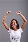 Joyful young woman raising her arms exulting