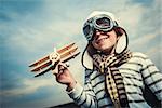 Smiling boy with wooden plane