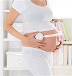 Pregnant woman putting headphones on her belly. Pregnancy relaxation at home.