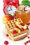 Belgian waffles with fruit and honey for breakfast.