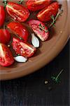 Fresh tomato salad with thyme and onion on a brown plate close up.