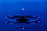 blue water drop reflected from the surface on which form circles