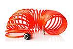 Orange red thin spiral air hose used for pneumatic tools. Isolated on white with natural reflection.