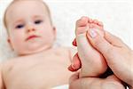 Baby foot massage - mother hands pampering child