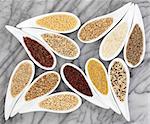 Grain food selection in white dishes over marble background.