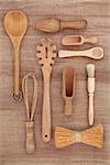 Wooden kitchen utensil selection over papyrus parchment background.