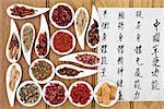 Traditional chinese herbal medicine with mandarin calligraphy on rice paper over oak background. Translation describes the medicinal functions to increase the bodys ability to maintain body and spirit health and balance energy.