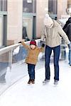 family of young mother and her son skating at winter