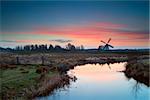 pink sunrise over Dutch windmill and river, Groningen