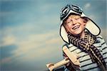 Laughing boy with a plane on the background of sky