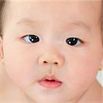 Close up face of Asian baby boy with curious look