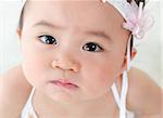 Close up face of Asian baby girl with curious look