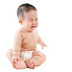 Full body upset Asian baby boy crying, sitting isolated on white background