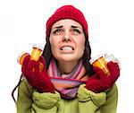 Sick Mixed Race Woman Wearing Winter Hat and Gloves Blowing Her Sore Nose and Holding Empty Medicine Bottle Isolated on White.