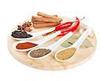 Colorful herbs and spices selection on cutting board. Isolated on white background