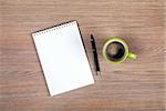 Blank notepad and coffee cup on office wooden table