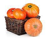 Ripe small pumpkins in basket. Isolated on white background