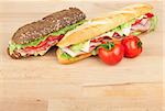 Fresh sandwiches with meat and vegetables and tomatoes on wood table