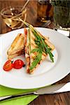 breakfast is served. Classic White bread sandwich with chicken, cheese, tomatoes, green salad, decorated with arugula on a white plate