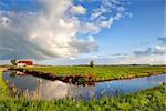 beautiful clouds over charming farmhouse and blue river