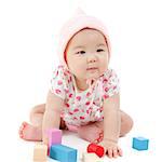 Adorable Asian baby girl playing wood blocks on floor, sitting isolated on white background.