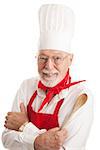 Handsome senior man in a chef's uniform, holding a wooden spoon.  Isolated on white.