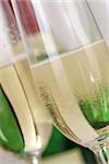 Champagne or sparkling wine with bubbles in a glass with a bottle in the background