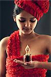 Portrait of young beautiful indian girl with bottle of perfume