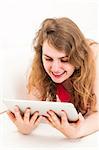 Smiling young woman on the couch with her tablet