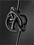 Black and white image of a black tangled flexible hose.