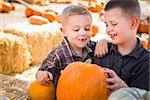 Two Boys at the Pumpkin Patch Talking About Their Pumpkins and Having Fun on a Fall Day.