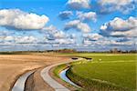 curved road under blue sky with nice cloudscape, Netherlands