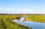 little wooden open bridge for bikes over Dutch canal, Holland