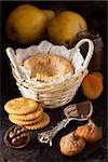 French cheese Lagres in a basket with dried fruits, nuts, crackers and confiture on a dark wooden background.