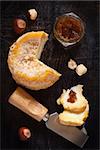 French cheese Lagres with confiture and nuts on an old wooden background.