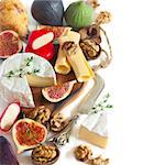 Assortment of delicious cheese and fruits on a white.