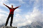 Young mountaineer standing on a rock and enjoying freedom in the mountains