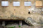 Aged wall with stairs and boarded up windows