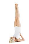 Full length of a fit young woman doing the shoulder stand pose over white background