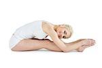 Full length side view of a toned young woman doing the paschimottanasana pose over white background