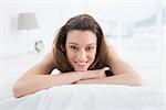 Close up portrait of a pretty young woman resting in bed at home