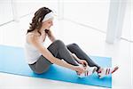 High angle view of a toned young woman wearing shoes on exercise mat at fitness studio