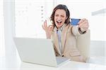 Businesswoman doing online shopping through laptop and credit card in office